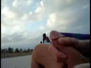 Amerikāņi tūrists raušana par the pludmale kamēr sieviete passing līdz video